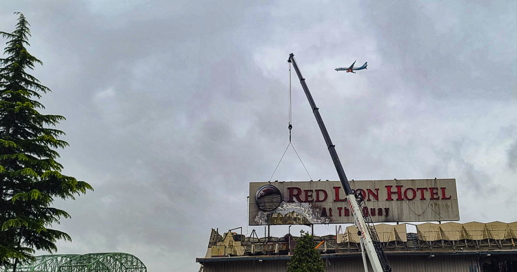 Passengers on this airplane destined for PDX got different perspectives of crews removing the Red Lion sign on Thursday. Photo by Paul Valencia