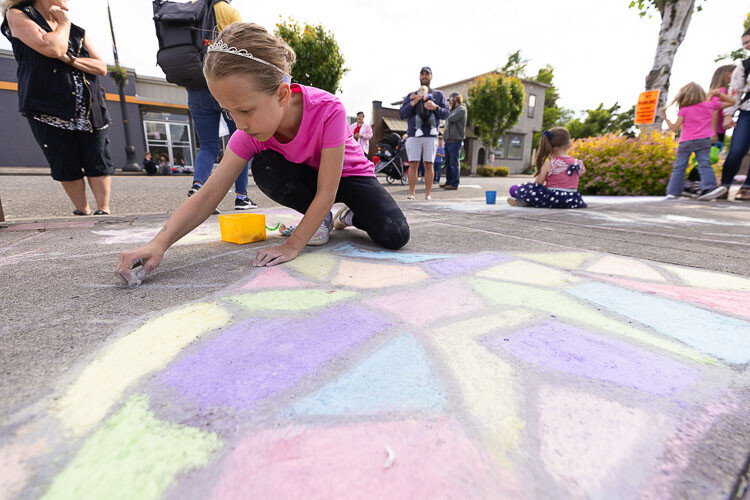Aria Tillman creates her work at the Children’s Chalk Art event on the first day of Planters Days in Woodland on Thursday. Photo by Mike Schultz