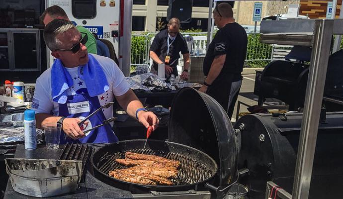 Jason Cuthbert, who grew up in Vancouver and works for the Washington State Patrol, checks up on the progress of the pork tenderloin he and his teammates were cooking up Sunday at the ilani BBQ Fest as part of the Operation BBQ Rescue competition. Photo by Paul Valencia