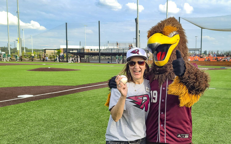 Jennifer Lindsay, the mayor of Ridgefield, is all smiles with Rally the Raptor after the mayor threw out the first pitch Wednesday as the Raptors opened their 2022 season. Photo by Paul Valencia