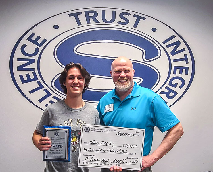Teddy Beaver of Skyview, along with Scott Evenson, the president of the Clark County chapter of the National Football Foundation, celebrate Beaver’s first-place selection in the backs category for the foundation’s annual scholarship awards. Photo by Paul Valencia