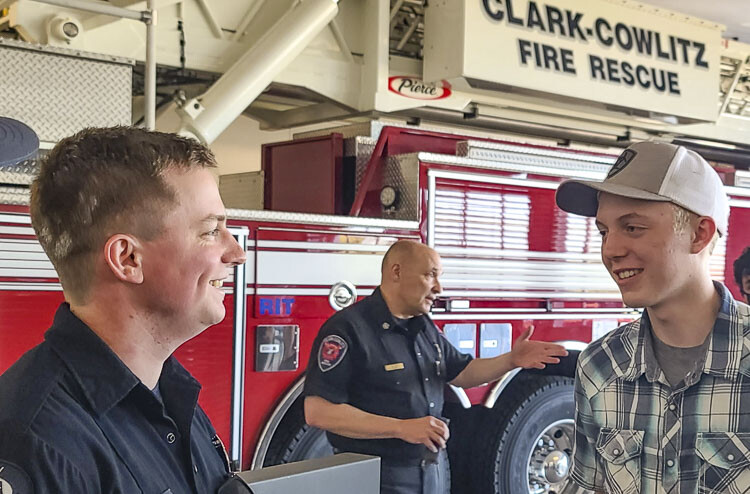 Triston Martell talks to firefighter Zach Galster on Thursday. Galster was one of the first responders to arrive at La Center High School after five school employees started life-saving efforts on Martell, who suffered a cardiac arrest. Photo by Paul Valencia
