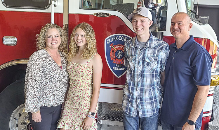 Triston Martell (in hat) stands with his dad Marcus, his mom Tiffany, and his sister Whitney on Thursday in front of a Clark-Cowlitz Fire Rescue vehicle. Triston, 15, suffered a cardiac arrest last month at La Center High School, and five school employees jumped into action to save his life. Photo by Paul Valencia