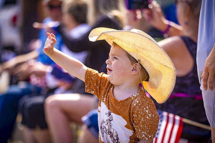 Waylon McFarland waves to participants in Saturday’s Territorial Days Parade. Photo by Mike Schultz