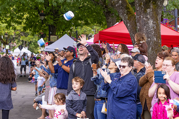 An onlooker attempts to catch a roll of toilet paper thrown from the Georgia Pacific entry in the Camas Days Parade. Photo by Mike Schultz