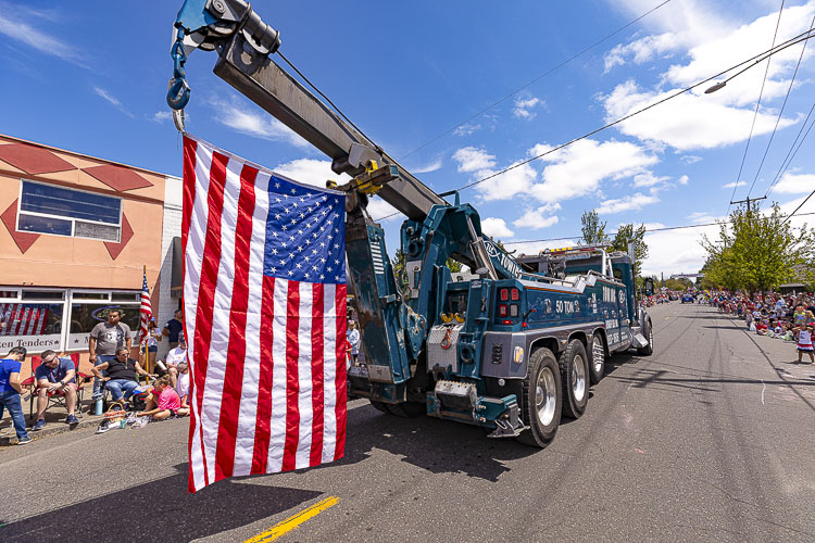 There were plenty of flags flying Monday at the Ridgefield 4th of July Parade, including this one offered by TLC Towing. Photo by Mike Schultz