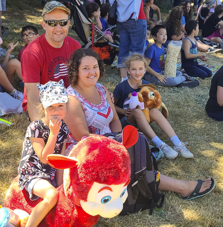 The Berezhnoy family of Vancouver — Oleg, Alla, Elsa, 10, and Milania, 5 — won stuffed animals then found a place to watch the parade Friday at the Clark County Fair. Photo by Paul Valencia