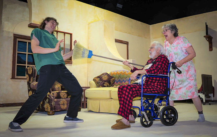 Don Quintero (Christopher Cleveland, middle) and Doris (Carol Radkins, left) engage in mock combat with group home worker Jimmy (Zane Jager, left). Photo courtesy Fetching Photos