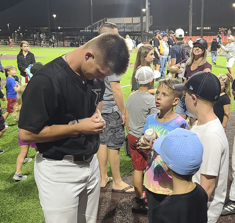 Riley McCarthy, a Mountain View High School graduate, had a key hit in Ridgefield’s playoff win on Tuesday and then signed autographs for young fans. He said the energy from the crowd was amazing. He loves how the community supports the Raptors. Photo by Paul Valencia