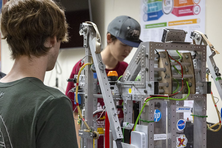 Prairie High School students Noah Pape (left) and Jared Femling examine a robot they helped design for the FIRST Robotics competition last year. Photo courtesy Battle Ground School District