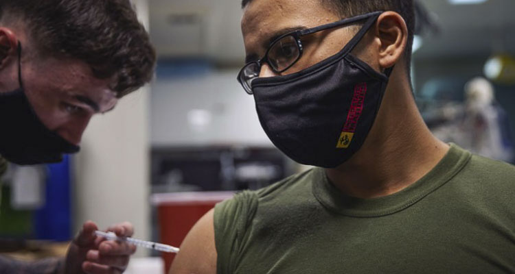 ATLANTIC OCEAN – Lance Cpl. Carlos Benitez, assigned to the 22nd Marine Expeditionary Unit, receives a COVID-19 booster shot aboard the Wasp-class amphibious assault ship USS Kearsarge (LHD 3) March 23, 2022. The Kearsarge Amphibious Ready Group with embarked 22nd Marine Expeditionary Unit is on a scheduled deployment in the U.S. 2nd Fleet area of operations. (U.S. Navy photo by Mass Communication Specialist 3rd Class Jesse Schwab)