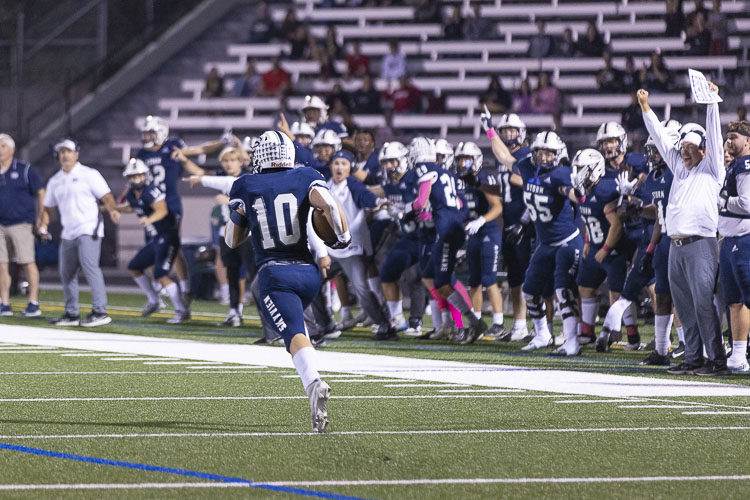 The Skyview sideline goes wild as Colby Warner returns an interception 99 yards for a touchdown. Photo by Mike Schultz
