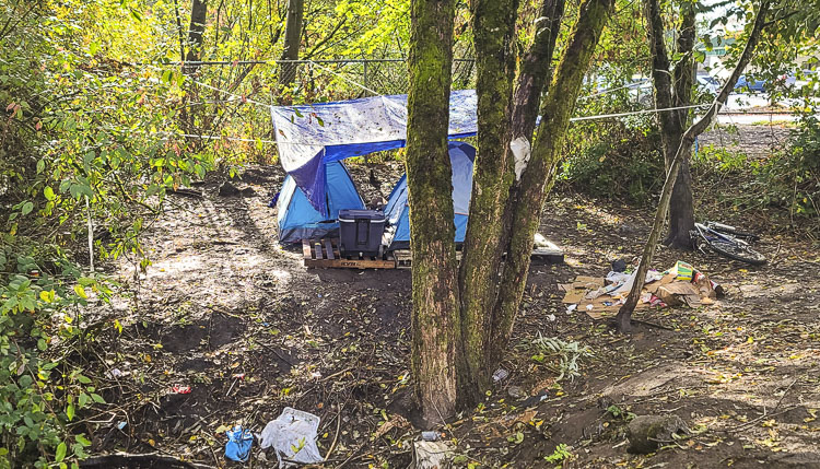 This campsite is just off the road at NE 107th Ave. and NE 53rd Street. There are several businesses nearby. Business owners have called for police response dozens of times in recent months. Photo by Paul Valencia