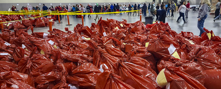 Once a bag of toys is filled for a family, it is placed in its spot, ready for pick-up on Sunday. The bags are divided into zip codes for easier delivery for Santa’s Posse. Photo by Paul Valencia