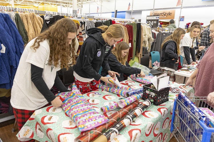 The Woodland High School girls basketball team helped out by wrapping presents. Photo by Mike Schultz