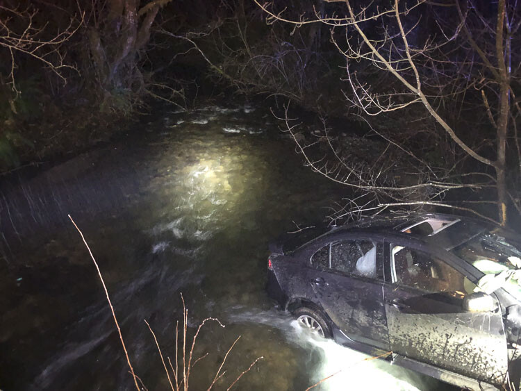 Deputies located a gray Mitsubishi Lancer down an embankment, partially in Boulder Creek, with two passengers still inside. Photo courtesy Clark County Sheriff’s Office