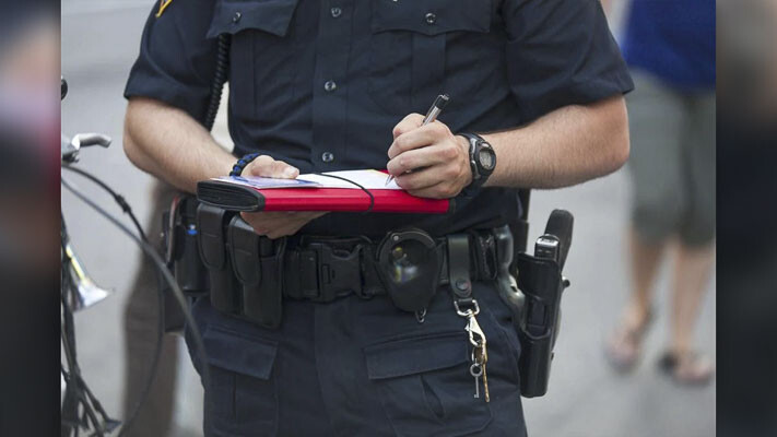 A police officer writes a citation. Photo courtesy Peter Factors/Shuttershock.com