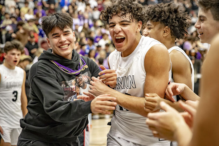 Yanni Fassilis of Union celebrates with teammates and fans after the Titans rallied to beat Camas last week. Fassilis said playing Camas the last two years has been the most fun he has had playing basketball, going up against a rival. Photo courtesy Heather Tianen