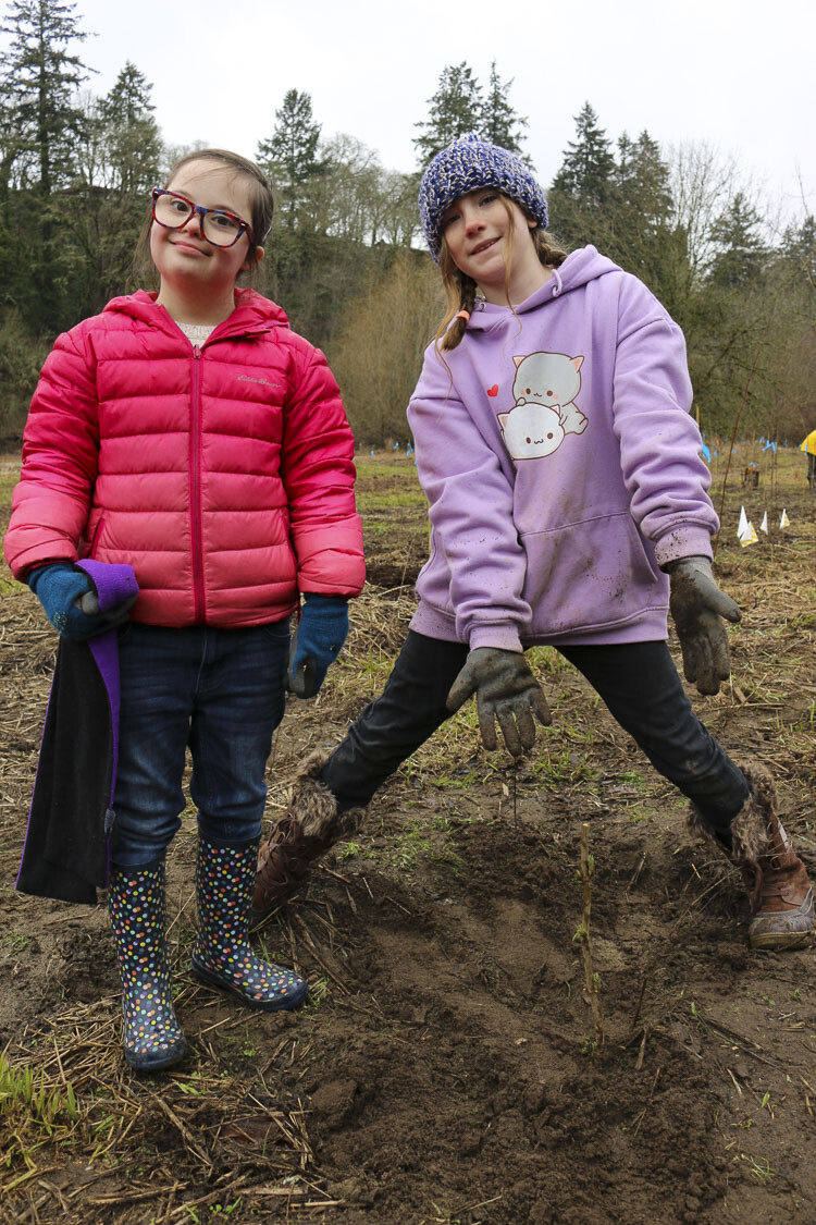 Olive Jackson and Hazel Johnson, students at Hockinson Heights Elementary School, proudly pose with a native shrub that they have freshly planted. Photo courtesy Hockinson School District