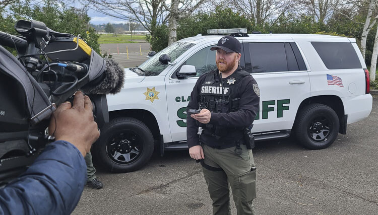 Chris Fisk, a deputy with the Clark County Sheriff’s Office, holds up the small camera that can be easily placed on his uniform vest. Photo by Paul Valencia