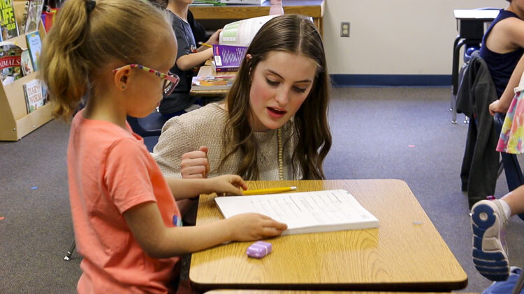 Gause Elementary student Penny Ligons is assisted by Washougal High School Student Claire Zakovics (right). Photo courtesy Washougal School District