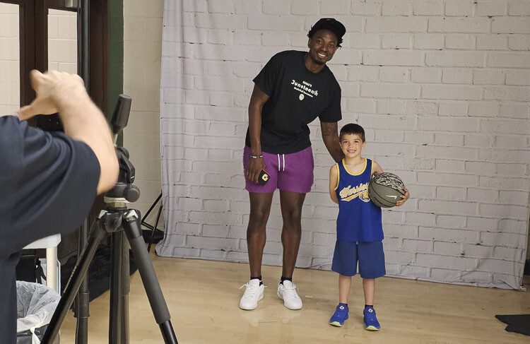 Robert Franks Jr. takes a picture with one of his young fans, Lucas Johnson, at the Robert Franks Jr. Juneteenth Basketball Tournament at Evergreen High School on Friday. Photo by Paul Valencia