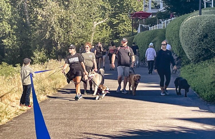 Sgt. Jeremy Brown’s wife Jill (front left in black) thanks a young volunteer holding the mile-long blue ribbon. Photo courtesy Leah Anaya