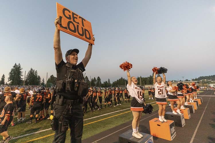 Phil Anderson of the Battle Ground Police Department got a little energetic at the football game Friday night, helping the Battle Ground cheer squad. Photo by Mike Schultz