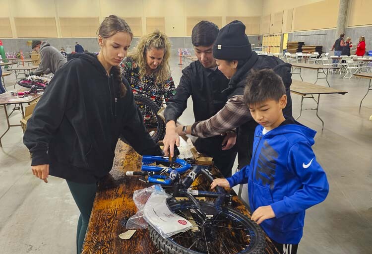 Members of the Washougal Church of Christ assemble a bicycle at the Bike Build on Saturday morning at the Clark County Fairgrounds. Photo by Paul Valencia