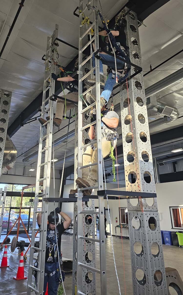 Students get a feel for the real life ladders they must climb after they graduate from the Northwest Renewable Energy Institute. Photo by Paul Valencia