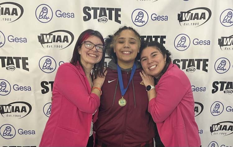 Faith Tarrant of Prairie (middle) celebrates her third state wrestling championship with coaches Cailey Mendez (left) and Foster Olson. Photo courtesy Faith Tarrant