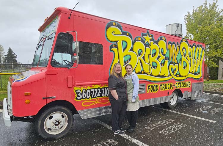 Kim Myers and her daughter Josie Jodenschwager stand in front of the Bribe My Belly truck recently. Kim is a part-time 9-1-1 dispatcher at CRESA and a cook, running a food truck in Clark County. Photo by Paul Valencia