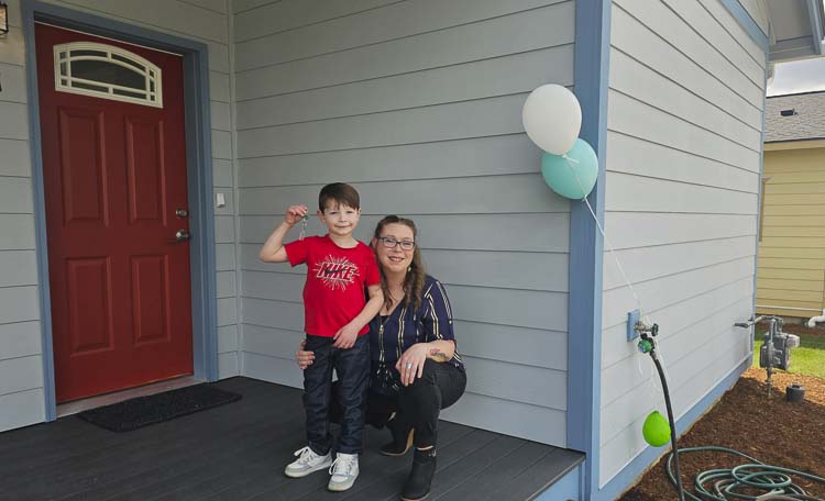 Nikki Goodman and her son Everett are all smiles, holding up the keys to their new home in Vancouver courtesy of Evergreen Habitat for Humanity. Photo by Paul Valencia