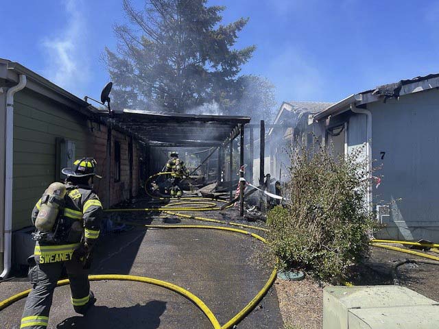 Vancouver Fire crews contained two burning homes and a brush fire in Oak Creek Mobile Home Park; five residents were displaced, no injuries reported.