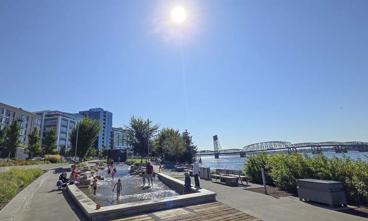 A few folks got to the water feature at the Vancouver Waterfront just before 11 a.m. Friday to find some cool fun. The forecast called for high 90s or low 100s Friday and Saturday in the region. Photo by Paul Valencia