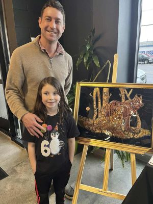 Theo and Larissa Marais enjoying a piece from David Gerton, one of the local artists featured on the passport. Photo courtesy Downtown Camas Association
