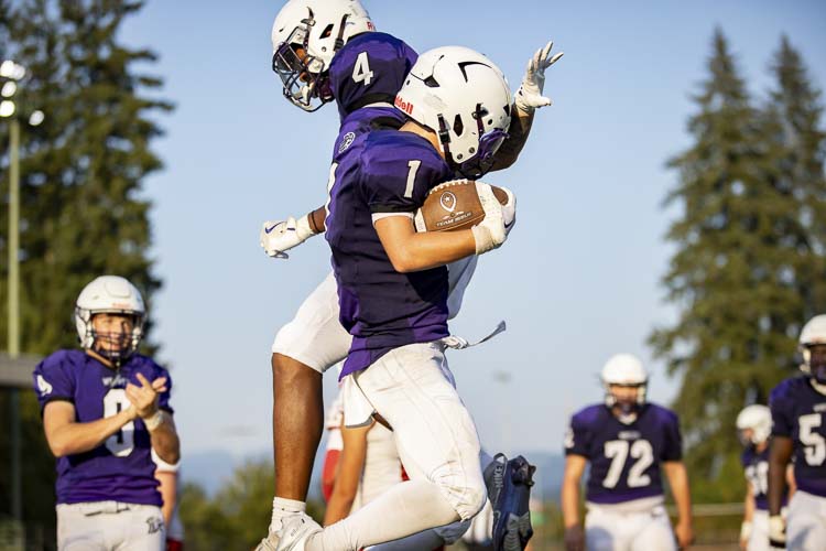 Heritage’s Treylon McGraw (1) and Dakari Bradford get some air during their celebration Friday at McKenzie Stadium. The Timberwolves beat Fort Vancouver to open their season. Photo courtesy Heather Tianen