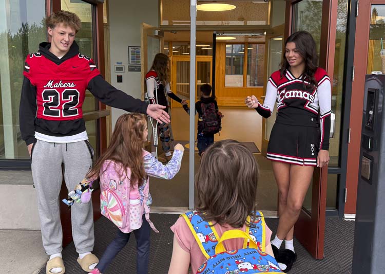 Camas football player Luke Parbon and Camas cheerleader Maya Harris greet students at LaCamas Lake Elementary School on Friday. Photo courtesy Camas High School Athletics
