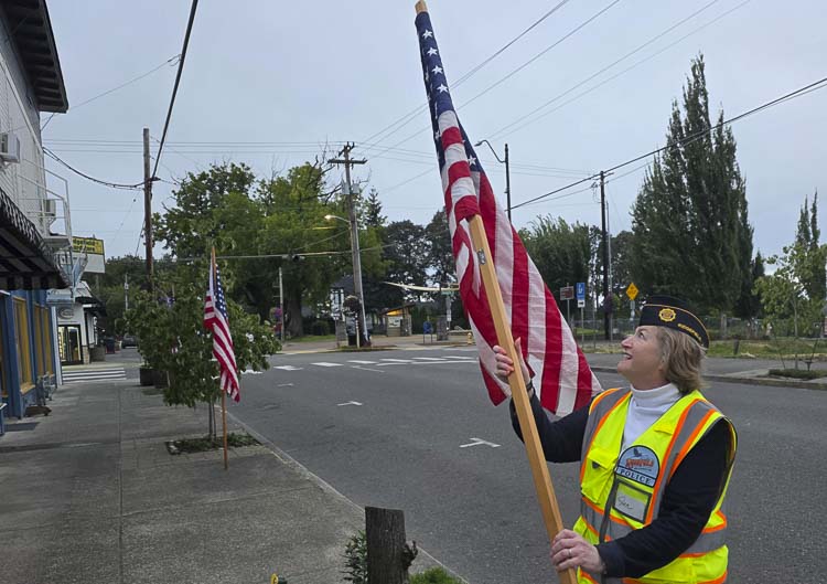 Jen McDonnell, commander of American Legion Post 44 Ridgefield and a U.S. Army veteran, posts an American flag Thursday in Ridgefield. Photo by Paul Valencia