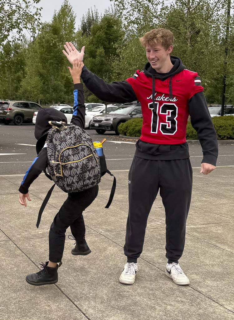 Camas senior Jack Parbon gives a high-five to a student from LaCamas Lake Elementary School on Friday. On the day of home football games, football players and cheerleaders from Camas High School visit Camas elementary schools to greet younger students and invite them to come to the game. Photo courtesy Camas High School Athletics