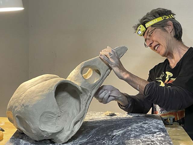 Clay artist Dian Gale working on a raven skull. Photo courtesy RedDoor Gallery