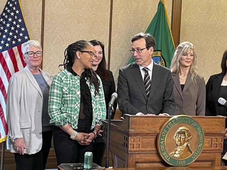 Washington Gov. Bob Ferguson congratulates Democratic state Rep. April Berg after signing her legislation dealing with the making of change in an era of fewer pennies. The bill was signed into law on March 23, 2026 in Olympia. Photo courtesy Jerry Cornfield/Washington State Standard