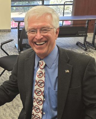 State Representative John Ley shows off his “No Income Tax” tie that he wore at a recent debate on the house floor. He had to remove the tie because it was deemed a prop. Still, he said, he got his point across during the debate. Photo by Paul Valencia