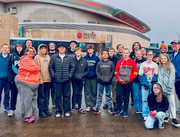Rocksolid Community Teen Center teens, staff, and interns gather outside the Moda Center while attending a Portland Trail Blazers game, reflecting the program’s focus on connection and community experiences. 