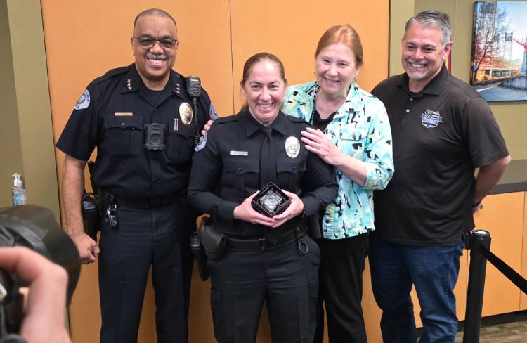 Vancouver Police Chief Troy Price, left, officer Holly Musser, Vancouver Mayor Anne McEnerny-Ogle, and Kindness 911 founder Jason Hattrick are all smiles after Musser was awarded the Kindness Cop of the Year award Monday at City Hall. Photo by Paul Valencia
