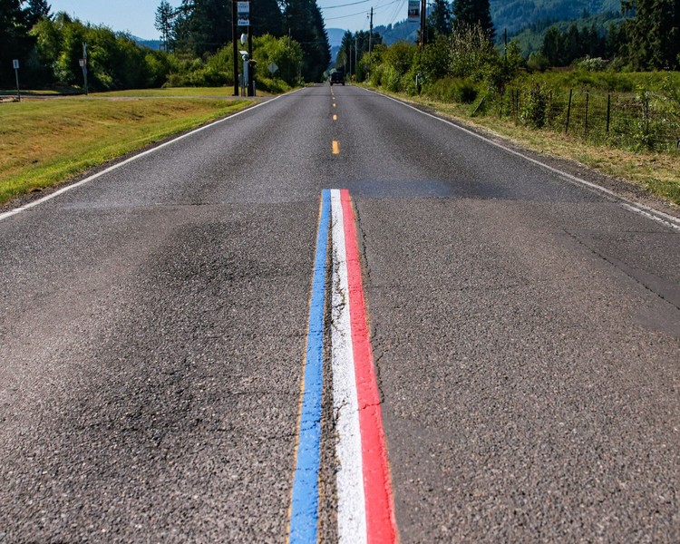 Red, white and blue centerline road striping ends at the town limits of Yacolt on Railroad Avenue. A complaint to the town may result in the centerline striping being painted over with standard yellow.