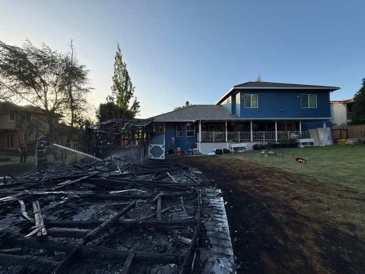 Four engines and two truck companies held a three-outbuilding blaze to the structures, sparing an adjacent home.