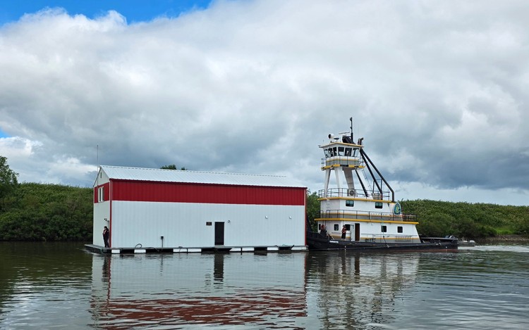 A tugboat slowly pushed the Clark-Cowlitz Fire Rescue boathouse along Lake River to its dock in Ridgefield on Wednesday. Photo by Paul Valencia