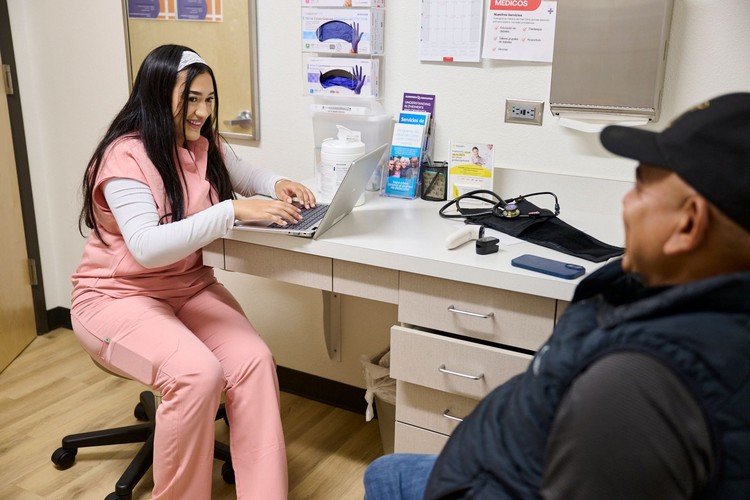 A medical assistant intern (left) assists with intake and assessment for a Free Clinic patient in Vancouver.