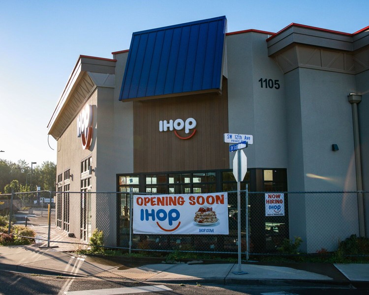 An "Opening Soon" banner and hiring sign hangs outside the future IHOP at 1105 SW Scotton Way on Friday, July 31.